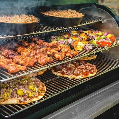 Traeger grill with lid open and food shown on cooking racks